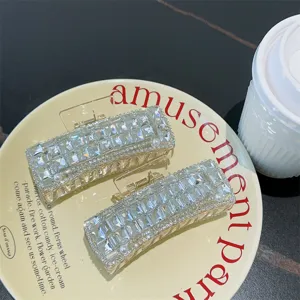 Nahaufnahme von glitzernden Strass-Haarklammern mit Perlendetails auf einem Teller.