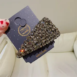 Vue détaillée d'une pince à cheveux triangle strass scintillante sur carte, accessoire élégant.