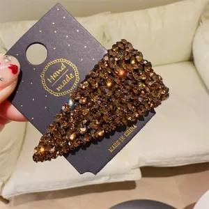 Détail pince à cheveux triangle strass marron, barrette cristal scintillante sur carte