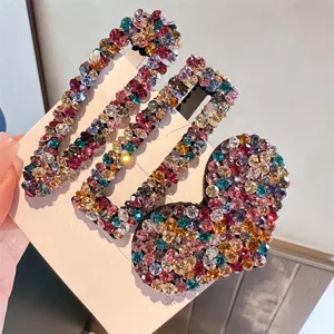 Nahaufnahme von funkelnden bunten Strass-Haarspangen mit geometrischen und süßen Herzmotiven.