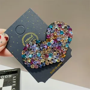 Detaillierte Nahaufnahme der Strass Herz Haarklammer mit bunten Kristallen auf Karte.