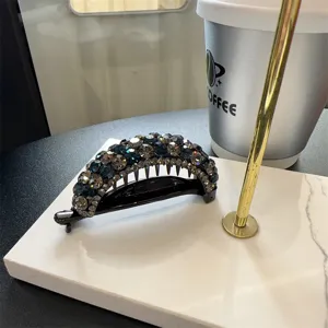 Vue détaillée d'une pince à cheveux banane en cristal scintillant avec des strass élégants.