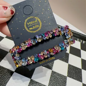 Detaillierte Nahaufnahme einer funkelnden Strass-Haarspange mit bunten Kristallen auf Karte.