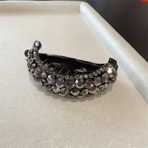 Détail rapproché d'une pince à cheveux banane en strass brillants, design en cristal élégant.