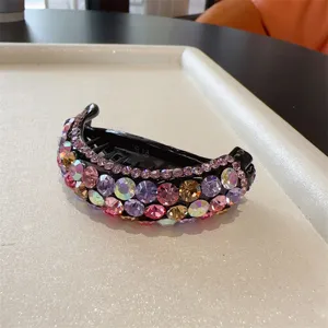 Vue détaillée d'une pince à cheveux banane en strass scintillants, pince élégante et incurvée.