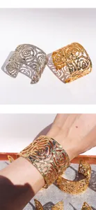 Detailed close-up shot of wide open cuff bracelet with hollow floral textured design.