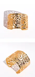 Wide gold tone metal cuff bracelet featuring openwork hollow rose floral textured design.