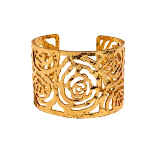 Wide gold cuff bracelet featuring hollow floral rose cutout and textured metal finish.