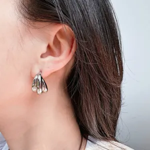 Silver geometric wavy drop earrings detail shot, chic metallic ear jewelry for women.