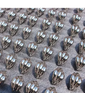 Detailed shot of silver metallic ridged drop earrings showing unique wave texture design.