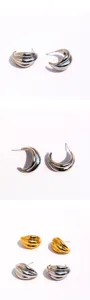 Chunky wave geometric metal hoop earrings detailed view, stylish curved design, shiny finish.