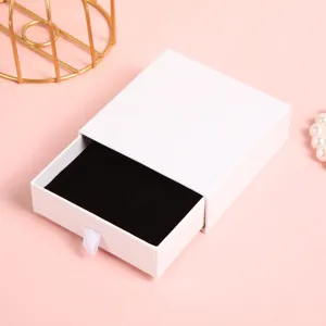 Vista dettagliata dell'elegante portagioie bianco a cassetto con interno in morbido velluto.