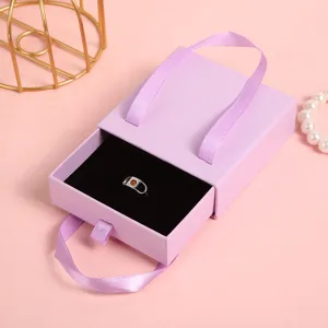Dettaglio scatola portagioie a cassetto viola con confezione elegante e interno nero.