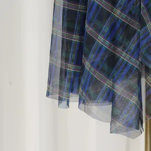 Blue plaid mesh skirt detail, lightweight tulle fabric, stylish summer garment close-up view.