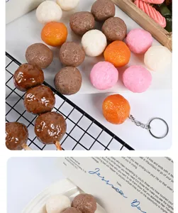 Primo piano dettagliato di modelli di polpette alimentari in PVC con vassoio a griglia e oggetti.