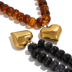 Vista detallada y cercana del elegante colgante de corazón dorado con finos abalorios.
