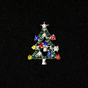 Détail de broche arbre de noël avec strass colorés sur accessoire en épingle en métal.