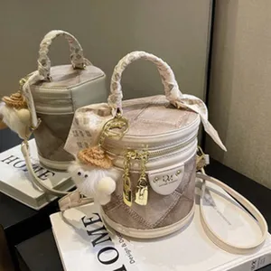 Quilted cylinder handbag with silk scarf handle and cute plush charm for women daily fashion.
