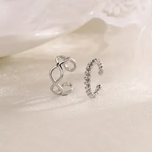 Detailed view of silver non-pierced ear cuffs, featuring geometric and twisted rope designs.
