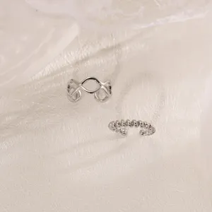 Silver geometric wave and twisted rope ear cuffs detail view, elegant clip-on jewelry item.