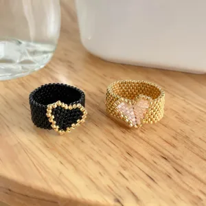 Dettaglio anello cuore di perline fatto a mano con lavorazione squisita e accessorio dolce.