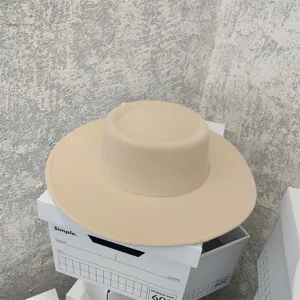 Detailed close up of the elegant beige flat top felt hat with a wide brim for autumn fashion.