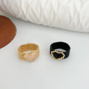 Primo piano di anelli di perle fatti a mano con simpatici motivi a cuore in oro nero.