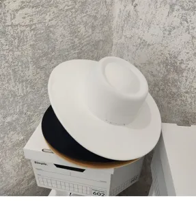Detailed view of french vintage wide brim flat top felt fedoras in white and black colors.