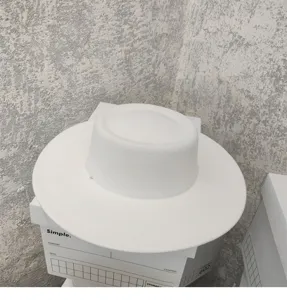 Detailed view of a white wide brim flat top fedora felt hat, elegant vintage winter style.
