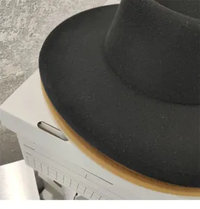 Close-up detail shot of black wide brim felt fedora hat winter fashion accessory