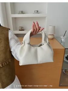 Detailed view of white pleated cloud shoulder bag, soft leather texture, elegant daily style.