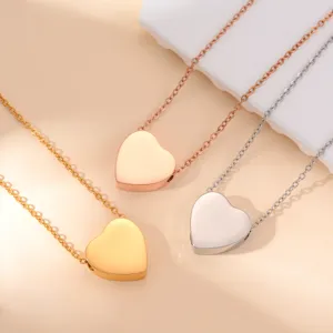 Stainless steel heart pendant necklace detail showing gold, rose gold, and silver finishes.