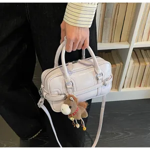 Detailed view of light purple patent mini handbag with plush horse charm for daily commute.