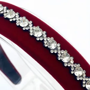 Sparkling rhinestone headband detail showing crystal stones on red velvet hair accessory.