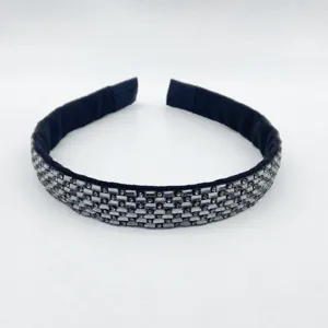 Detailed view of the sparkling rhinestone headband, featuring multi-row crystals and black velvet.