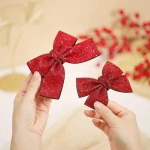 Red rhinestone bow hair clip detail view for festive holiday styling and elegant hair accessories.