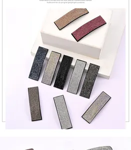Vista dettagliata di fermagli per capelli con strass scintillanti in vari colori caramella e design.