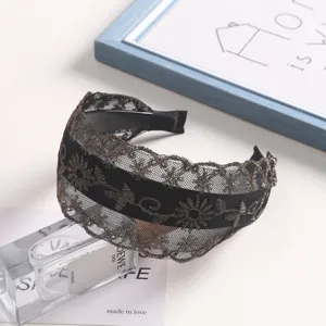Black lace embroidered headband detail showing delicate gold floral pattern and inner teeth.