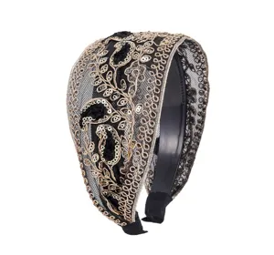 Detailed view of stylish black mesh sequin embroidered headband with elegant gold paisley pattern.