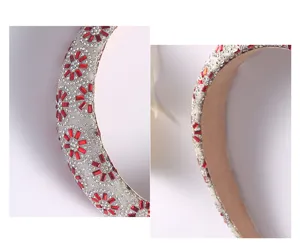 Détail de serre-tête tournesol en strass cristal scintillant, pierres rouges et transparentes.