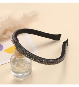Close-up detail shot of a sparkling rhinestone encrusted headband, elegant hair accessory.