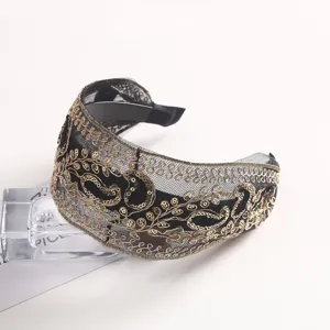 Detailed view of luxury black mesh gold sequin paisley embroidery headband elegant hair hoop.