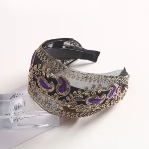 Detailed view of black mesh headband with gold embroidery and purple velvet paisley accents.