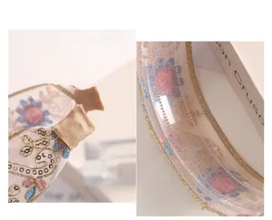 Delicate embroidered floral headband with gold trim and non-slip inner teeth for women.