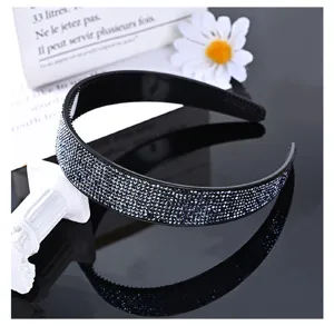 Detail view of the stylish wide rhinestone headband, sparkling crystals on black base.