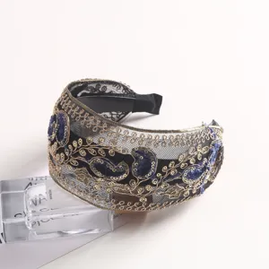 Elegant embroidered mesh headband with gold paisley patterns and blue velvet accents for women.