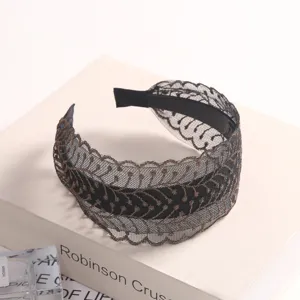 Close-up of black gold embroidered lace headband with anti-slip teeth and fine hollow texture.