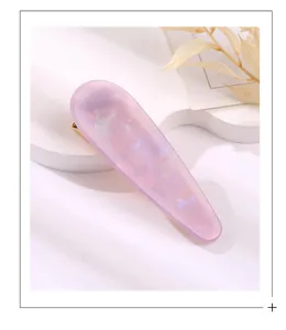 Detailed shot of the translucent pink acrylic waterdrop hair clip with gold tone clip.