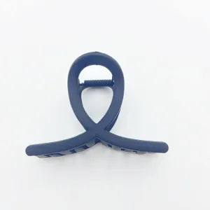Black matte hair claw clip detail close up showing the unique loop design and spring mechanism