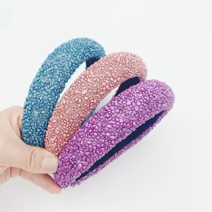 Primo piano di cerchi per capelli larghi e strutturati in blu, rosa e viola, accessorio moda.